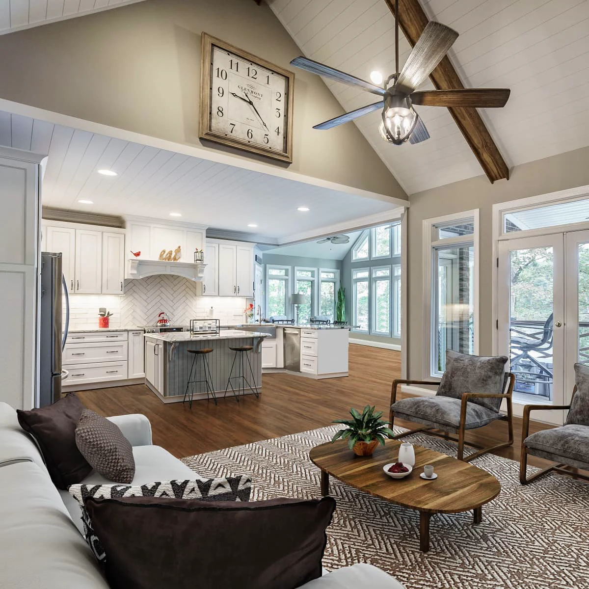 Vaulted living room with an exposed wood beam and ceiling fan, open to a white kitchen with a gray island and two bar stools